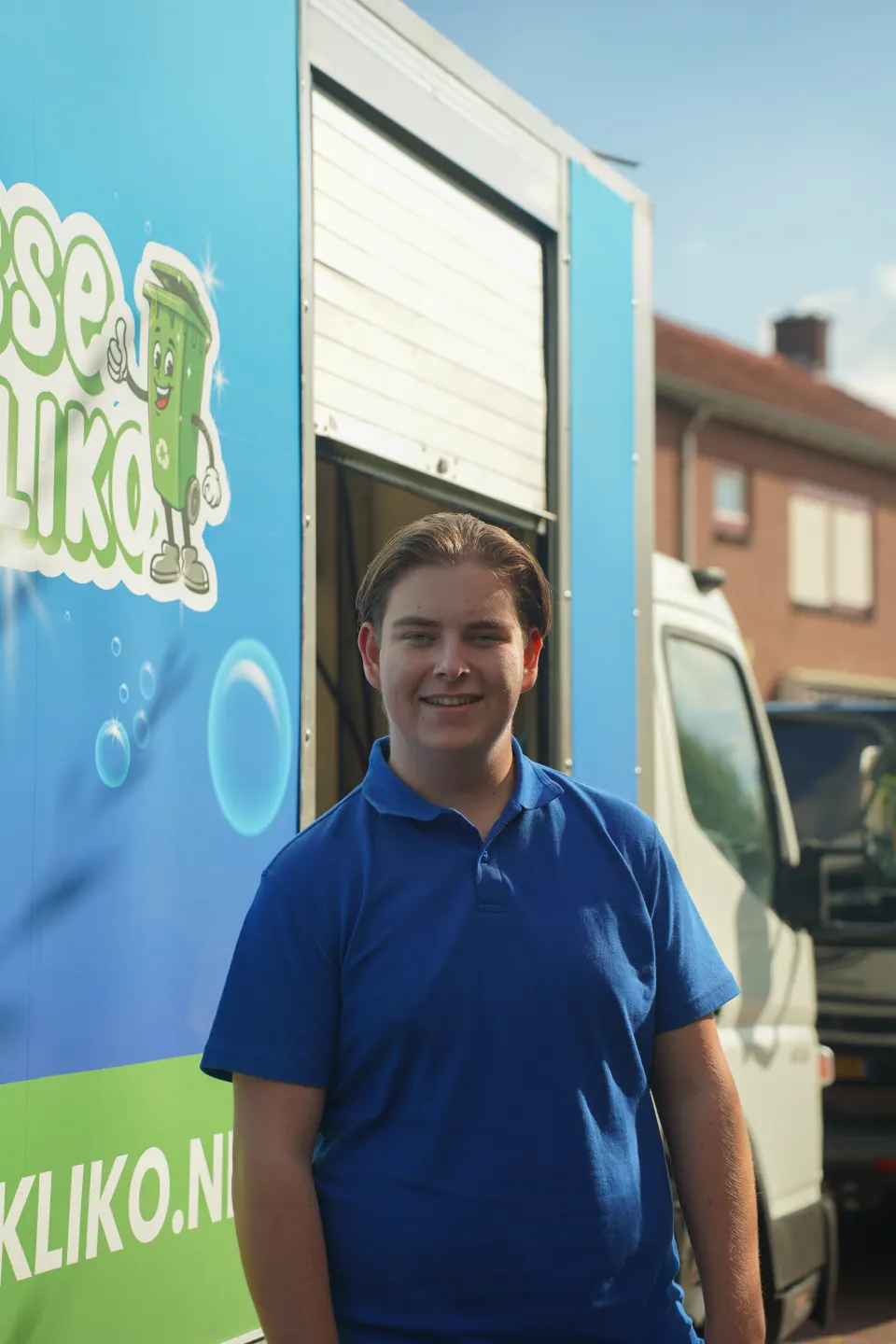 Frisse Kliko-medewerker naast de reinigingswagen met het Frisse Kliko-logo.